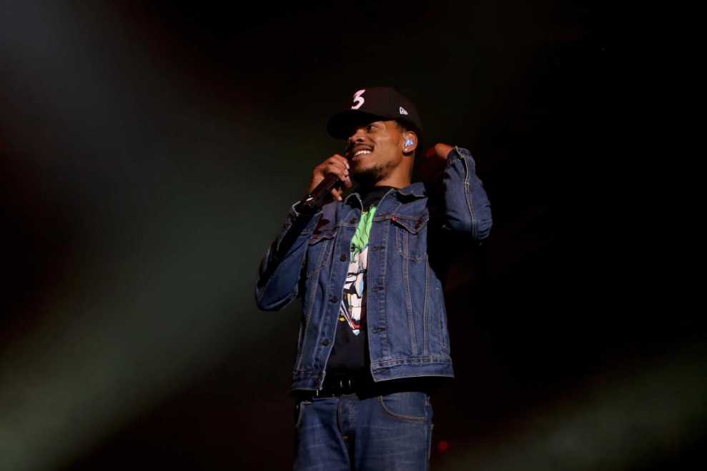 Chance the Rapper performing in black baseball cap reading 3