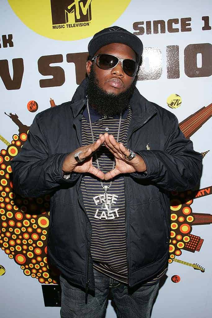 Freeway in front of MTV Studio sign wearing Free At Last medallion and with hands in a triangle