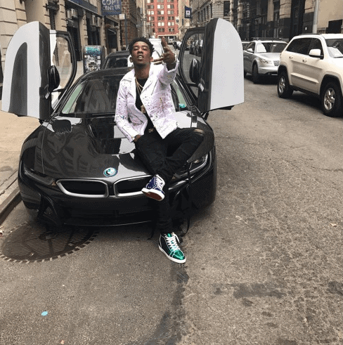 Desiigner on hood of black car