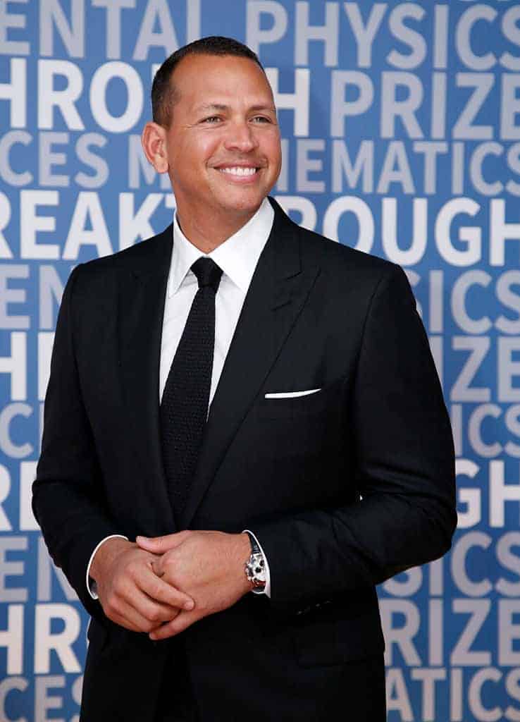 Alex Rodrigez in suit against blue background with white words on it