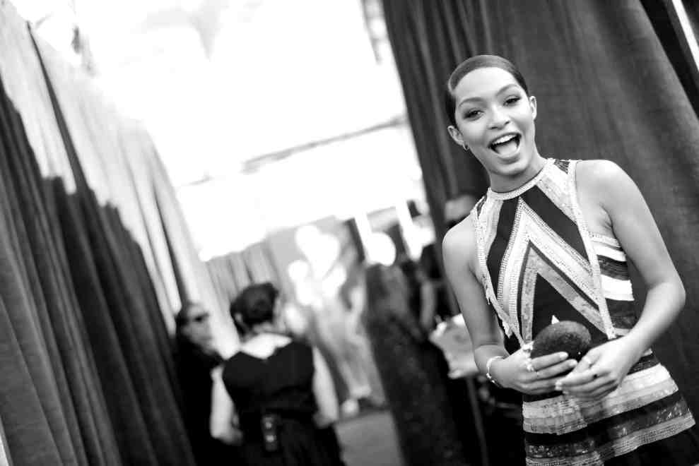 Black and white photo of Yara Shahidi smiling backstage at event