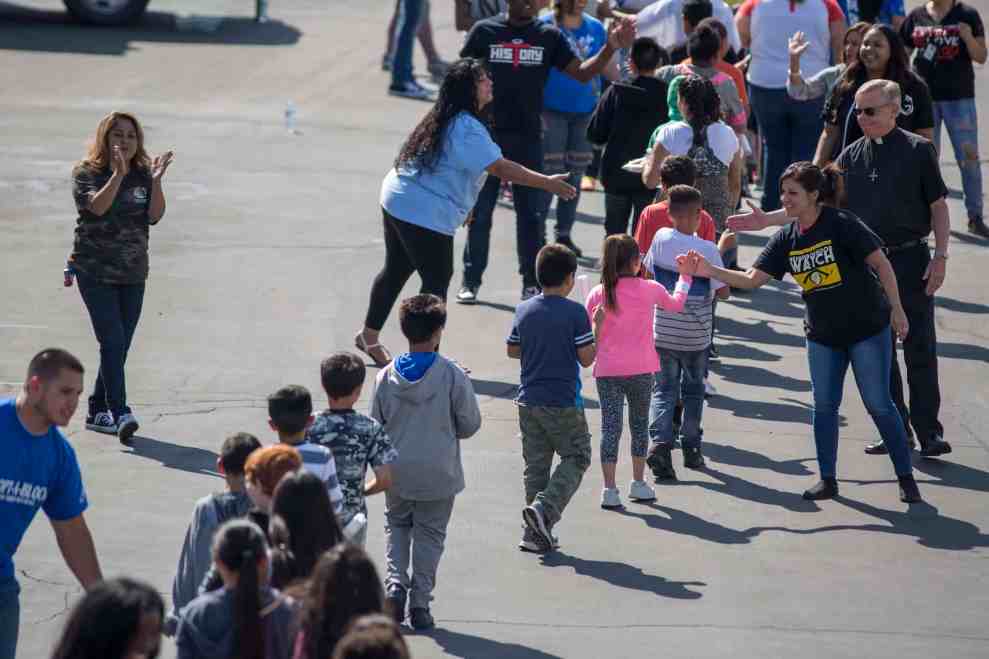 School kids in line giving high fives to people