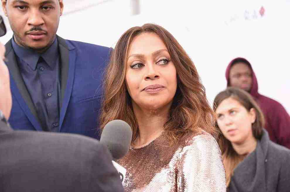 LaLa in front of a microphone with Carmelo Anthony behind her