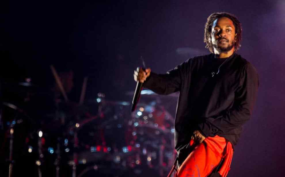 Kendrick Lamar performing in orange pants in 2019.
