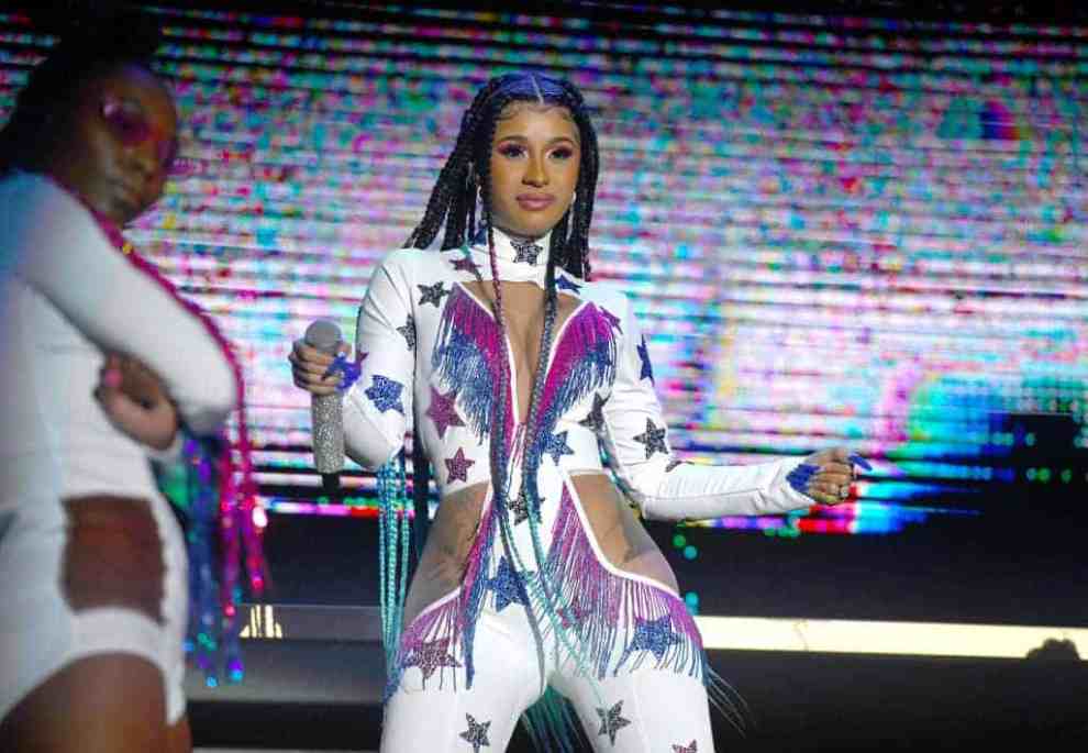 Cardi B wearing multi colored outfit on stage