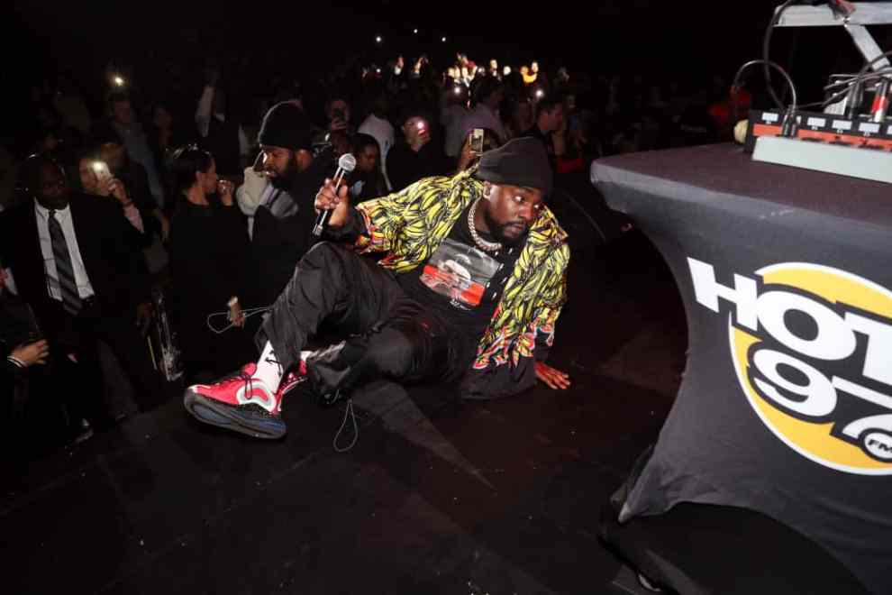 Wale sitting on stage at Hot for the Holidays