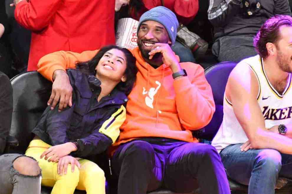 Kobe and Gianna Bryant smiling while sitting courtside