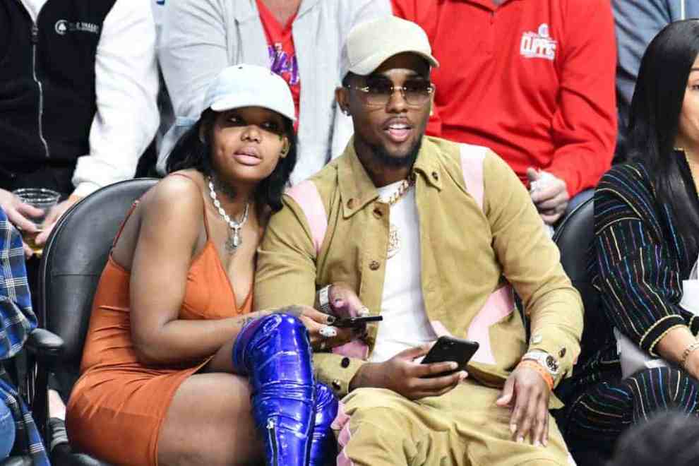 Summer Walker and London On Da Track sitting courtside at a basketball game