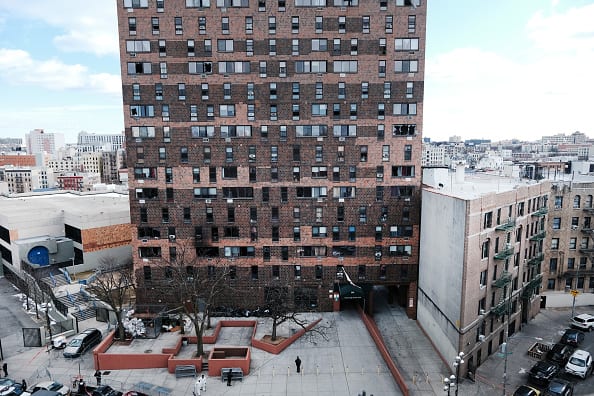 The Bronx apartment building stands a day after a fire swept through the complex killing at least 17 people and injuring dozens of others