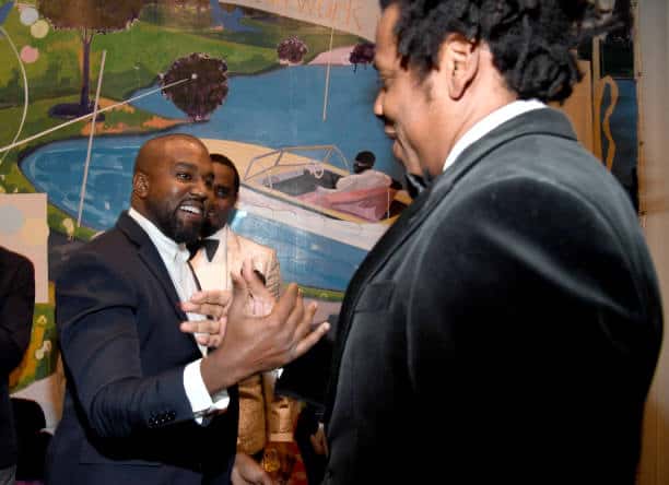 Kanye West and Jay -z greeting each other smiling