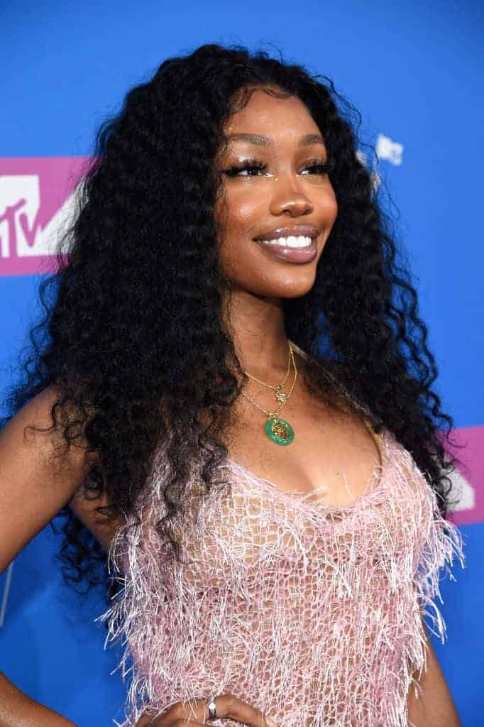 SZA wearing a dress smiling at the camera