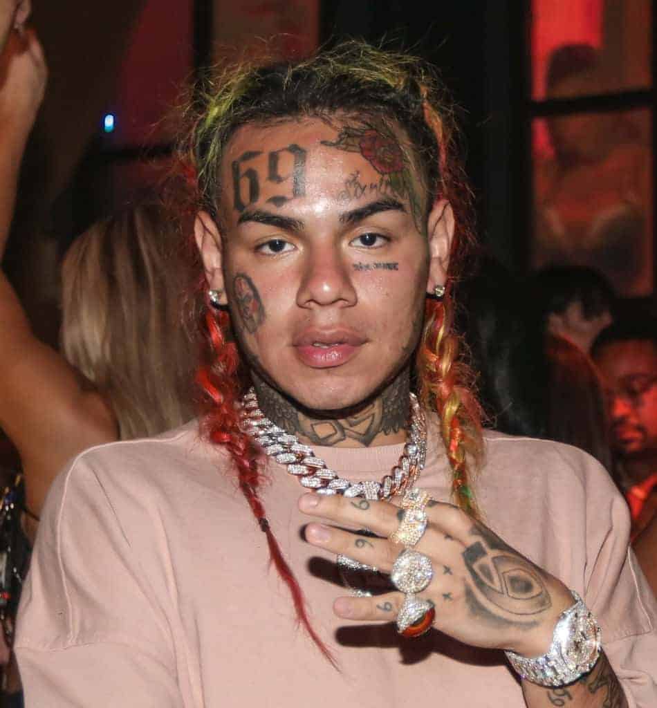 Tekashi 69 facing the camera showing his rings on hand