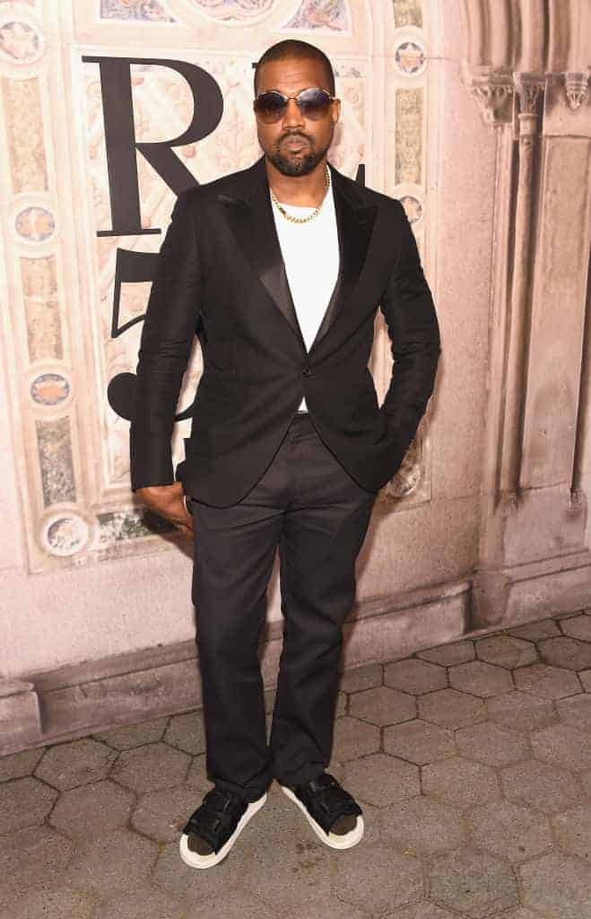 Kanye West wearing a black suit