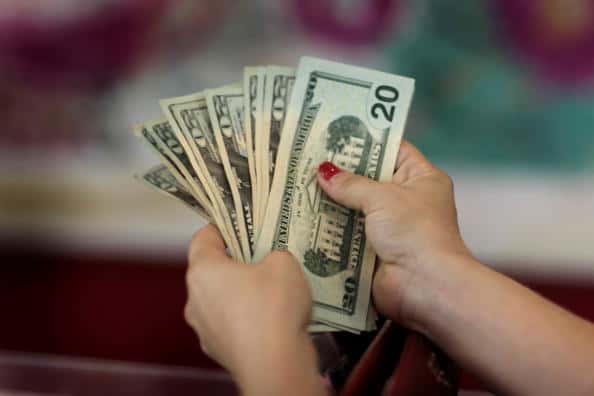 Wendy Levitz holds a handful of money as she shops for clothes at the Cherry Green apparel store on September 14