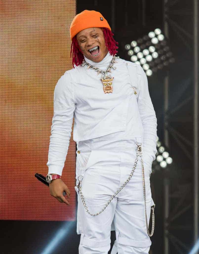 Trippie Redd wearing all white with an Orange Hat