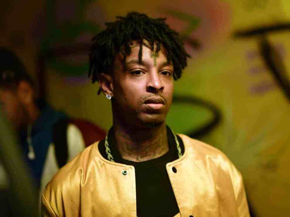 21 Savage wearing a gold jacket