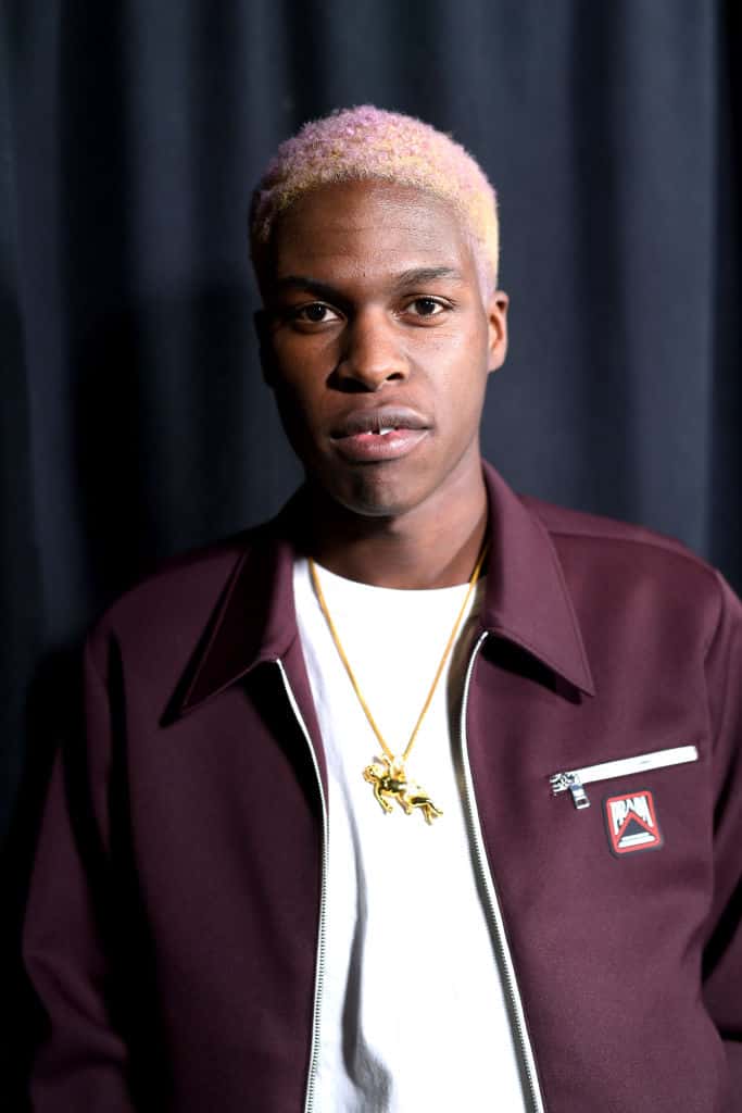 Daniel Caesar wearing a burgundy jacket