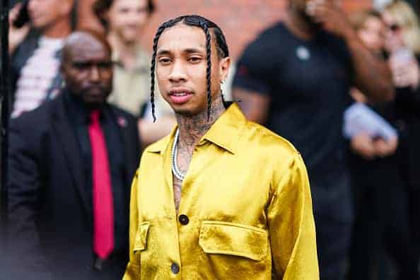 Tyga wears a yellow shiny shirt