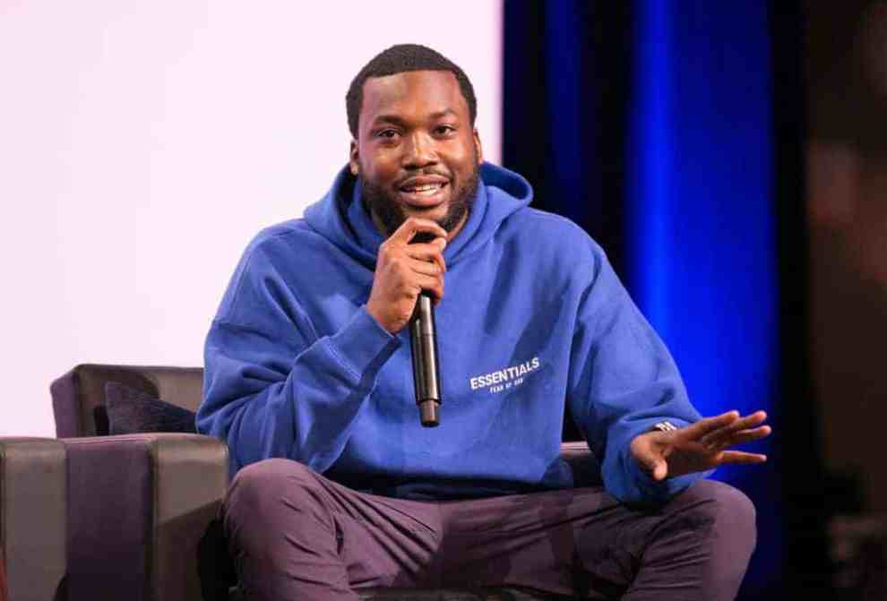 Meek Mill wearing a blue shirt holding a microphone