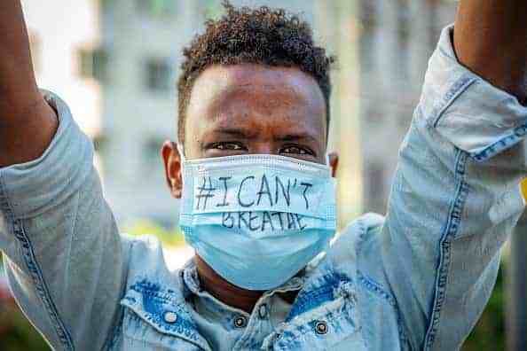 A protest with signs and masks reading I Cant Breath