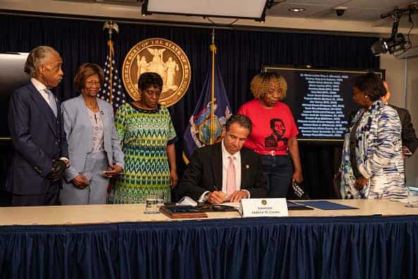 Governor Andrew Cuomo signs the "Say Their Name" reform during the daily media briefing as he is joined by (L-R) Rev. Al Sharpton