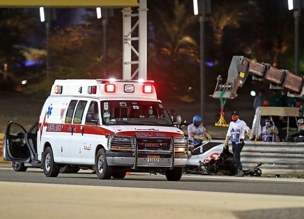 An ambulance passes next to Haas F1's French driver Romain Grosjean's car during the Bahrain Formula One Grand Prix at the Bahrain International Circuit in the city of Sakhir on November 29