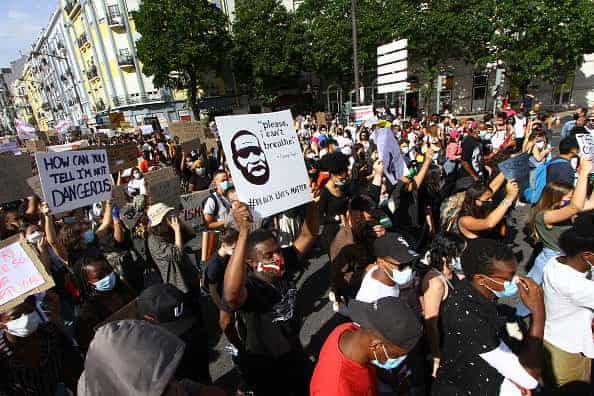 Protesters hold up posters during a march against racism