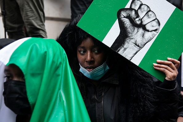 Protesters hold placards and signs calling for the end of police killings of the public in Nigeria