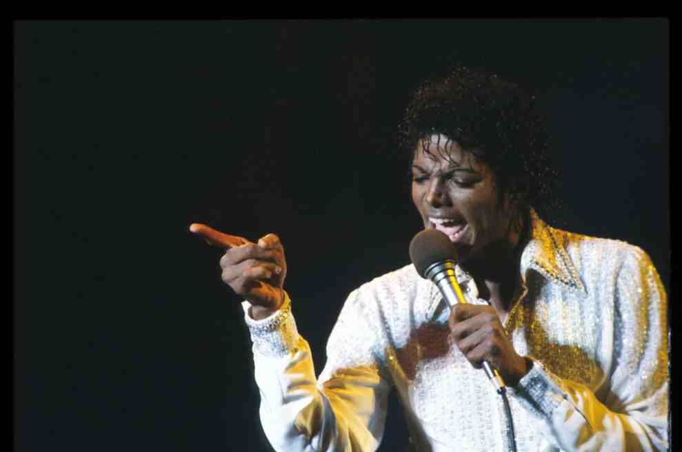 Michael Jackson performing on stage wearing a white shirt