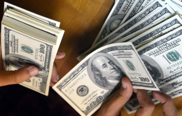 An employee counts USD notes at a money change outlet in Jakarta on June 14