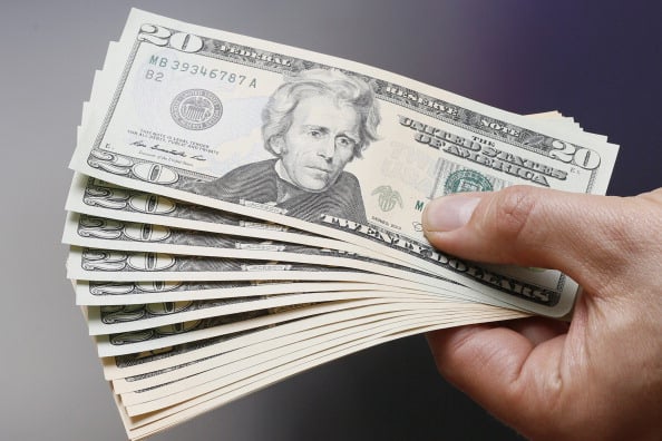 Businessman holding dollar bills in his hands on July 02