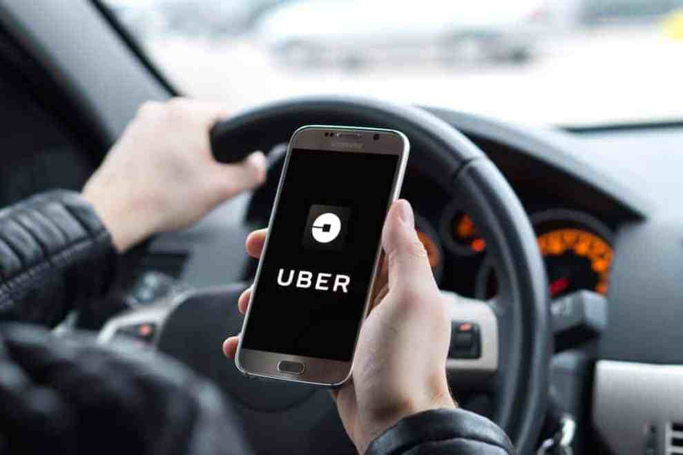 Uber driver holding a smart phone with the Uber app