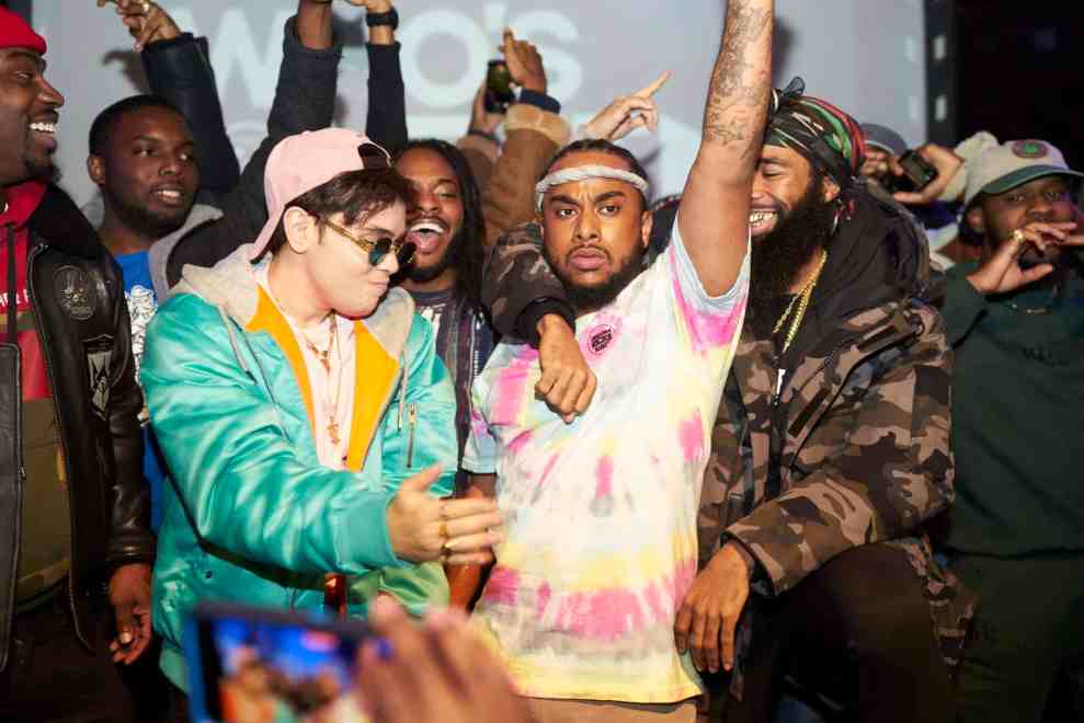 Rich P Surrounded By A Crew Embracing Him On Stage